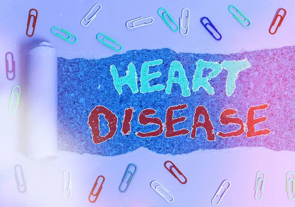 Word writing text Heart Disease. Business concept for A type of disease that affects the heart or blood vessels Rolled ripped torn cardboard placed above a wooden classic table backdrop.