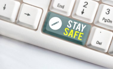 Kelime yazarken dikkatli ol. Tehlikeden, zarardan ya da makaleleri beyaz pc klavyesinde beyaz nota kağıdının üzerinde tutacak yerlerden korunmak için iş konsepti.