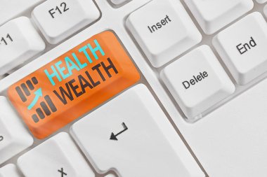 El yazısı Sağlık Serveti. Sağlıklı zihin ve beden anlamına gelen kavram size zenginlik ve mutluluk getirebilir beyaz pc klavye boş nota kağıdı beyaz anahtar kopya alanı üzerinde.