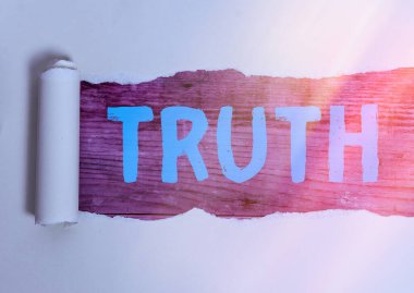 Gerçek 'i yazan el yazısı metinleri. Kavram kavramı, ahşap bir klasik masa arkaplanının üzerine yerleştirilmiş gerçek gerçeklik ya da sadakat anlamına gelir..