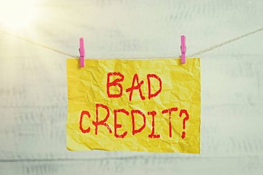 Kelime yazma metni Kötü Kredi Sorusu. Borçların ödenmemesinden kaynaklanan kötü kredi puanı için iş kavramı Çamaşır ipi, mandal şekilli kağıt anımsatıcı beyaz tahta masa.