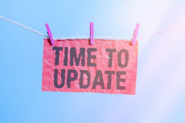 Güncelleme Zamanı adlı metin yazımı. Konsept, geliştirme veya uyumluluk için Sistem yazılım güncellemesi anlamına gelir Çamaşır ipi çamaşır ipi dikdörtgeni şekilli kağıt anımsatıcı beyaz tahta masa.