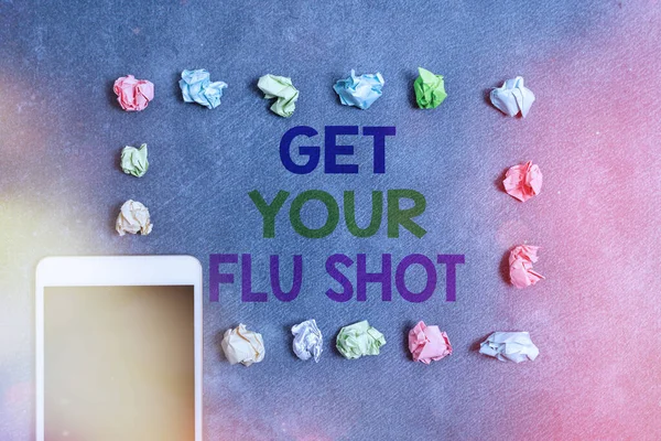 Writing note showing Get Your Flu Shot. Business photo showcasing immunization is given yearly to protect against the influenza Paper accessories with smartphone arranged on different background.