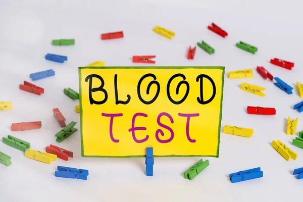 写上验血的字条商业照片展示从生物体中提取血液样本进行实验室分析彩色服装针纸空白提醒白底背景 — 图库照片