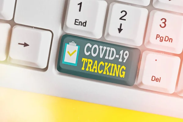 Schrijfbriefje met Covid 19 Tracking. Zakelijke foto presentatie Onderscheidend proces van de mogelijke geïnfecteerde personen Witte pc toetsenbord met lege nota papier boven witte sleutel kopieerruimte. — Stockfoto