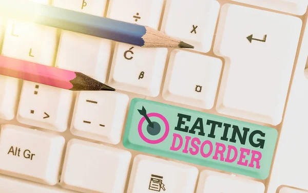 Text sign showing Eating Disorder. Conceptual photo illnesses or severe disturbances in their eating behaviors White pc keyboard with empty note paper above white key copy space. — Stock Photo, Image