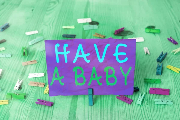 Psaní textu mít dítě. Koncept znamená, že rodiče očekávají nebo budou mít novorozence barevné zmačkané obdélník ve tvaru připomenutí papír světle modré pozadí. — Stock fotografie