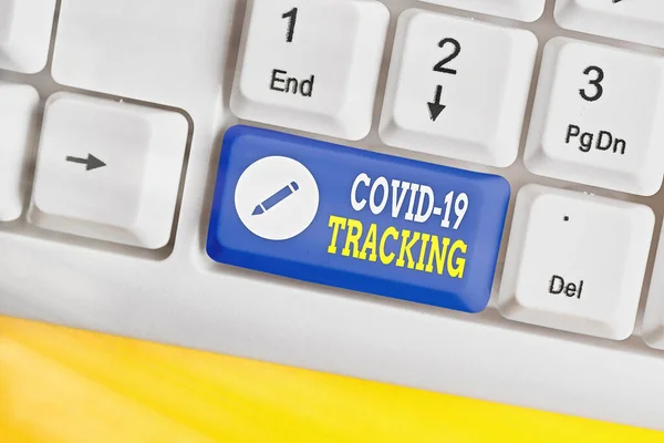 Woord schrijven tekst Covid 19 Tracking. Zakelijk concept voor Onderscheidend proces van de mogelijke geïnfecteerde personen Witte pc toetsenbord met lege nota papier boven witte sleutel kopieerruimte. — Stockfoto