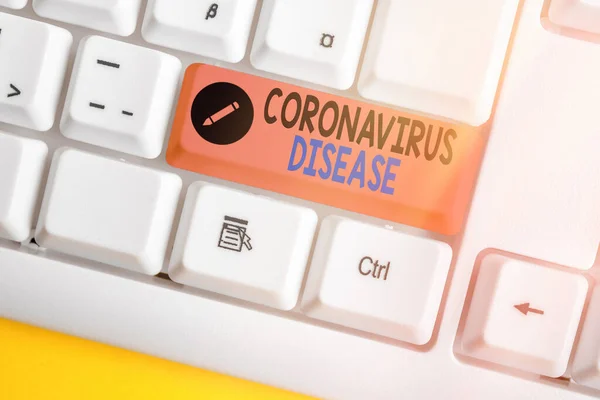 Γράμμα που δείχνει τη νόσο του Coronavirus. Επαγγελματική φωτογραφία προβάλλοντας ορίζεται ως ασθένεια που προκαλείται από ένα νέο ιό SARSCoV2 Λευκό πληκτρολόγιο PC με άδειο χαρτί σημείωμα πάνω από λευκό κλειδί αντίγραφο χώρο. — Φωτογραφία Αρχείου