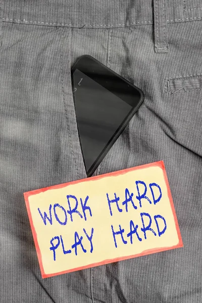 Написание рукописного текста Work Hard Play Hard. Концепция означает старательный в любой деятельности партии в выходные дни трудолюбивый смартфон устройство внутри формальных рабочих брюк передний карман рядом с бумагой . — стоковое фото
