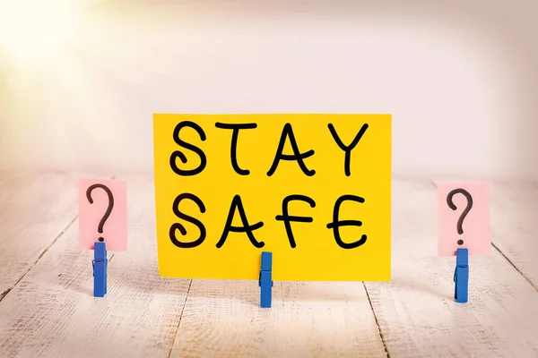 Conceptuele handschrift toont Stay Safe. Zakelijke foto tekst beveiligd tegen dreiging van gevaar, schade of plaats om artikelen te houden Afbrokkelend blad met paperclips geplaatst op de houten tafel. — Stockfoto