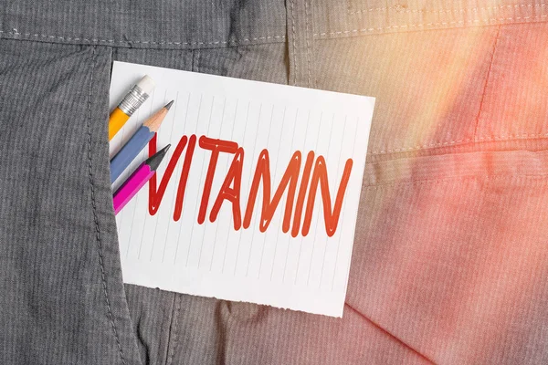 Word writing text Vitamin. Business concept for organic molecule that is essential micronutrient that organism needs Writing equipment and white note paper inside pocket of man work trousers. — Stock Photo, Image