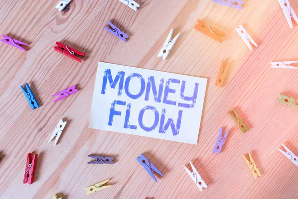 Handwriting text Money Flow. Concept meaning it is an indicator of positive or negative in a current day Colored clothespin papers empty reminder wooden floor background office.