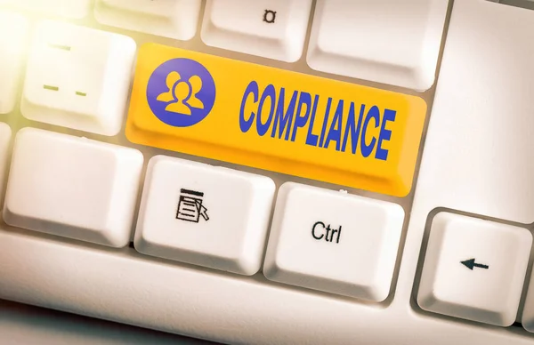 Conceptual hand writing showing Compliance. Business photo text the action or fact of complying with a wish or commands White pc keyboard with empty note paper above white key copy space.