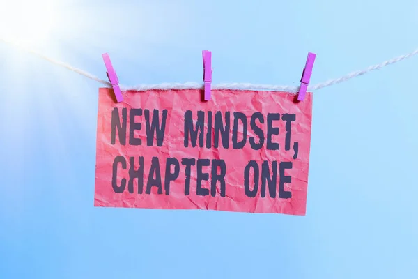 Написання тексту New Mindset, Chapter One. Концепція означає зміну ставлення і мислення Поліпшити важку роботу Clothesline clothespin прямокутний папір нагадування білому дерев'яному столу. — стокове фото