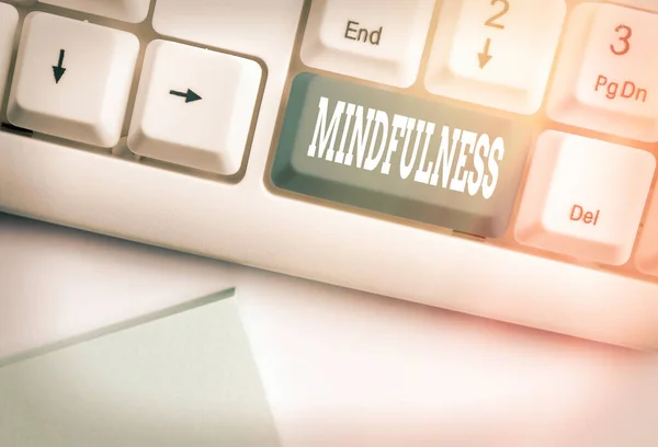 Conceptual hand writing showing Mindfulness. Business photo text state of mind attained by concentrating one s is attention White pc keyboard with empty note paper above white key copy space.