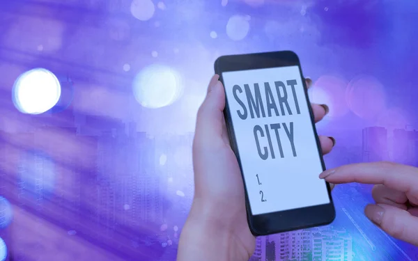 Psaný text Smart City. Obchodní koncept pro městskou oblast, která využívá komunikační technologie pro sběr dat Moderní přístroje s bílým displejem obrazovky pod barevným bokeh pozadí. — Stock fotografie