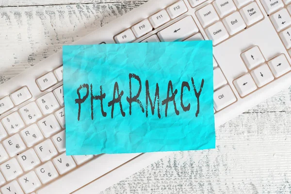 Text sign showing Pharmacy. Conceptual photo the practice of prescription drug preparation and dispensing White keyboard office supplies empty rectangle shaped paper reminder wood.