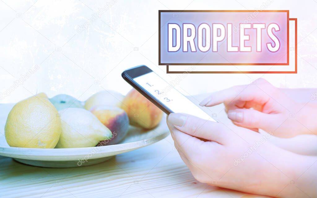 Conceptual hand writing showing Droplets. Business photo text very small drop of a liquid can be found in certain wet places Modern gadgets white screen under colorful bokeh background.