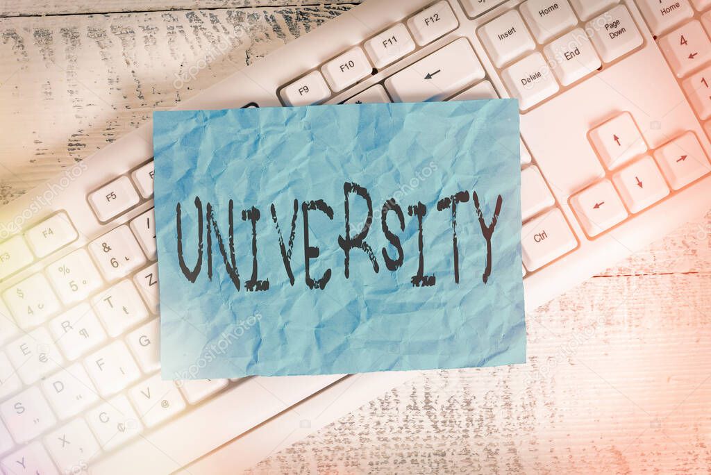Text sign showing University. Conceptual photo an educational institution designed to teach and investigate White keyboard office supplies empty rectangle shaped paper reminder wood.