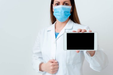 Tıbbi Gecelik Giyen, Ameliyat Eldiveni Giyen, Farklı Açı Atışları Boş Yapıştırma Kağıt Aksesuarlarıyla Çekilen Modern Akıllı Telefon