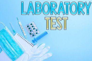 Laboratuvar Testi 'ni gösteren not yazılıyor. Sağlık durumu değerlendirmesi için not defteri ile test edilen tıbbi ekipman setinden tıbbi teşhisin belirlendiğini gösteren iş fotoğrafı..