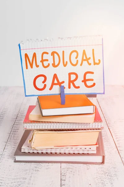 Text sign showing Medical Care. Conceptual photo the professional attention of medical practitioners in health pile stacked books notebook pin clothespin colored reminder white wooden.