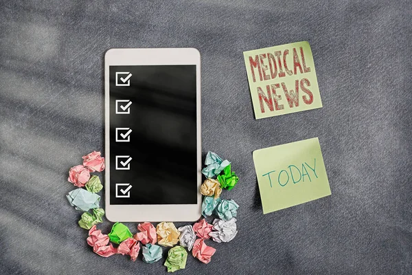 Conceptual hand writing showing Medical News. Business photo showcasing report or noteworthy information on a medical breakthrough Paper accessories with smartphone on different background.