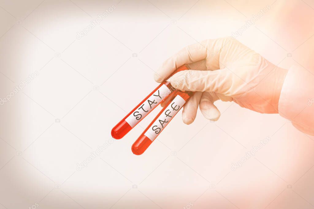 Word writing text Stay Safe. Business concept for secure from threat of danger, harm or place to keep articles Extracted blood sample vial ready for medical diagnostic examination.