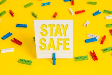 Güvenli Kalın 'ı gösteren kavramsal el yazısı. İş fotoğrafı sergisi tehlike, zarar ya da eşya saklama tehdidinden korunuyor. Renkli çamaşır iğnesi kağıtları boş sarı zemin ofisi..