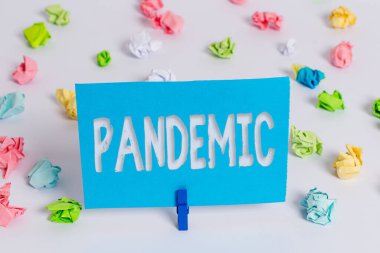 Salgını gösteren bir not yazıyorum. İş fotoğraflarının geniş bir alanda yayınlanması nüfusun yüksek oranını etkiliyor. Renkli buruşmuş kağıt boş hatırlatıcı beyaz zemin mandalı..