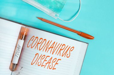 Kelime yazma Coronavirus Hastalığı. Yeni bir virüs olan SARSCoV2 'nin yol açtığı hastalık olarak tanımlanan iş konsepti, tıbbi aksesuarlarla birlikte çıkarılmış kan örneği şişesi incelemeye hazır..