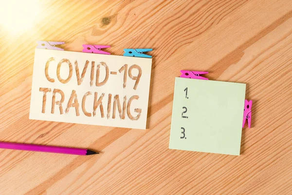 Writing note showing Covid 19 Tracking. Business photo showcasing Distinguishing process of the possible infected individuals Colored clothespin papers empty reminder wooden floor background office. — Stock Photo, Image