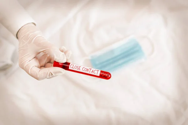Handwriting text Close Contact. Concept meaning having a history of direct exposure to a casepatient Extracted blood sample vial ready for medical diagnostic examination.