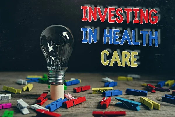 Conceptual hand writing showing Investing In Health Care. Business photo text put money on maintenance or improvement of health Realistic colored vintage light bulbs, idea sign solution.
