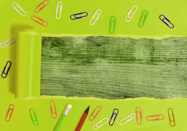 Gewalst gescheurd karton met wekkerklok en pennen geplaatst Ontworpen boven houten tafel. Dikke gescheurd papier op een gestructureerde houten achtergrond. Artistieke manier van het regelen van Flat Lays Fotografie — Stockfoto