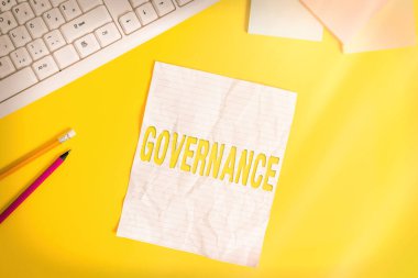 Word writing text Governance. Business concept for exercised in handling an economic situation in a nation Copy space on notebook above yellow background with pc keyboard on the table. clipart