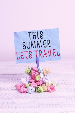 Bu Yaz Gezisi 'ni gösteren kavramsal el yazısı. Bir yerden başka bir yere seyahati gösteren bir iş fotoğrafı. Renkli, buruşuk kağıt çamaşır mandalı yığını..