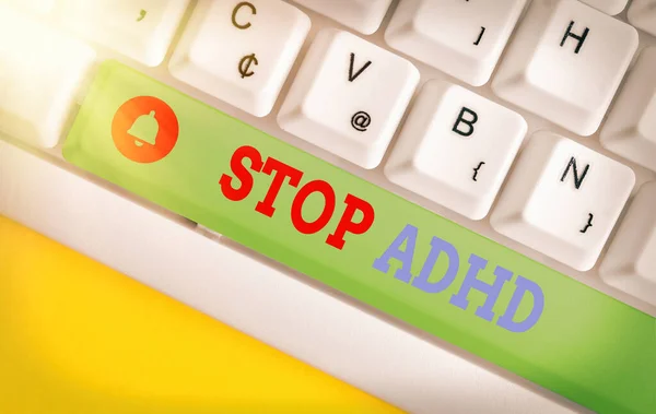 Conceptual hand writing showing Stop Adhd. Business photo showcasing treat a disorder that affects the brain and behaviors of a child Colored keyboard key with accessories arranged on copy space.