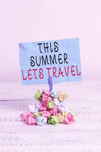 Bu Yaz Gezisi 'ni gösteren kavramsal el yazısı. Bir yerden başka bir yere seyahati gösteren bir iş fotoğrafı. Renkli, buruşuk kağıt çamaşır mandalı yığını..