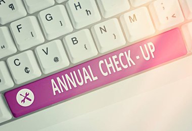 Yıllık kontrolleri gösteren bir not yazıyorum. Bir sağlık hizmeti sağlayıcısı ile yıllık üreme sağlığı ziyaretinin yer aldığı iş fotoğrafı gösterimi boş fotokopi alanına aksesuarlar yerleştirilmiş renkli klavye anahtarı.