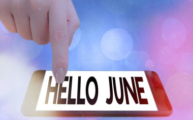 Hello June 'u gösteren bir not yazıyorum. Eğlence ve macera için etkinliklerinizi planlamak üzere yeni bir ay boyunca iş fotoğraflarınızı sergiliyorsunuz. Renkli arka plan altında modern cihazlar beyaz ekran..