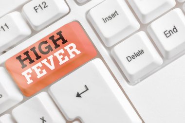 Yüksek ateşi gösteren kavramsal el yazısı. İş fotoğrafı tıbbi durumu: Beyaz tuş boşluğunun üzerinde boş not kağıdı bulunan gövde sıcaklığı normalden daha yüksek.