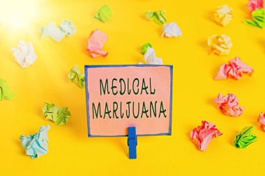 Tıbbi Marihuana 'ya mesaj yazıyorum. Sadece reçeteyle satılan ve hastalığın tedavisinde kullanılan iş konsepti Renkli buruşuk kağıtlar boş hatırlatıcı beyaz zemin çamaşır mandalı.