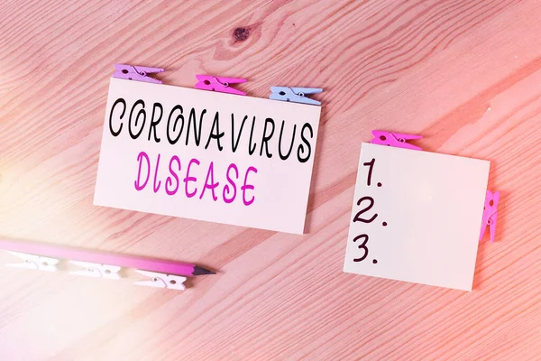 Ordskrivning text Coronavirus sjukdom. Affärsidé för definieras som sjukdom som orsakas av ett nytt virus SARSCoV2 Färgade klädnypor papper tom påminnelse trägolv bakgrundskontor. — Stockfoto