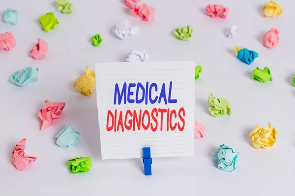 Word writing text Medical Diagnostics. Business concept for act of identifying a disease from its signs and symptoms Colored crumpled papers empty reminder white floor background clothespin.