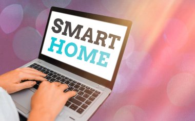 Smart Home 'u gösteren bir not yazıyorum. İş fotoğraflarıyla donatılmış ev, renkli bokeh arkaplan altında telefon ya da bilgisayar ile uzaktan kontrol edilebilir..