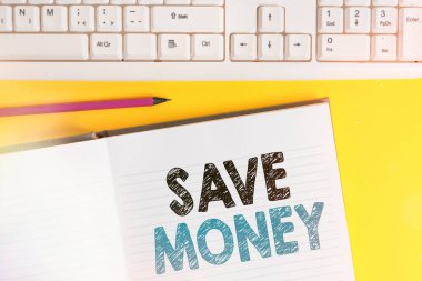 Kelime yazma metni Para Kaydet. Gelecek ya da acil durum için bütçe ayırmak ya da kenara para koymak için iş konsepti. Not defterine sarı arkaplan üzerinde klavye olan alanı kopyala.