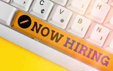 El yazısı şimdi işe alıyor. Konsept, pozisyon için nitelikli birini çalıştırma eylemi anlamına gelir. Boş kopya alanı üzerinde aksesuarlar düzenlenmiş farklı renkli klavye anahtarı.