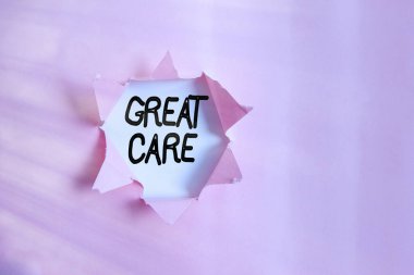 Harika Bakım 'ın el yazısı. Kavram, diğerlerine ilgi, saygı, sevgi ve rahatlık vermek anlamına gelir. Tahta bir klasik masa arkaplanının üzerine yerleştirilmiş parçalanmış karton..